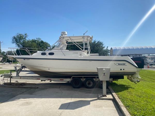 Boston Whaler 28 Conquest 2001 Boston Whaler 28 Conquest boat on trailer, parked outdoors under clear sky.