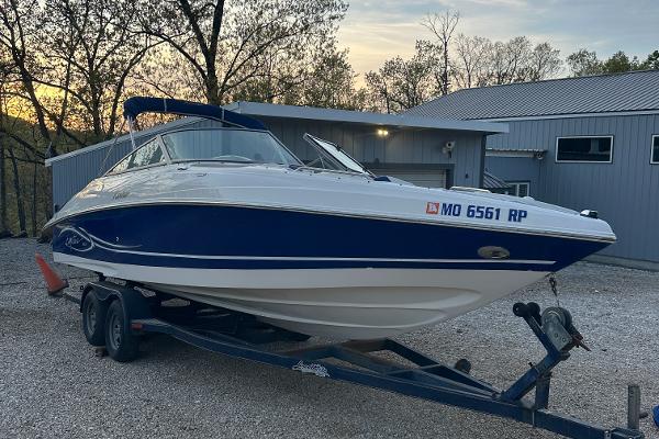 Rinker 262 Captiva Bowrider 2006 Rinker 262 Captiva Bowrider on trailer, parked near a building at sunset.