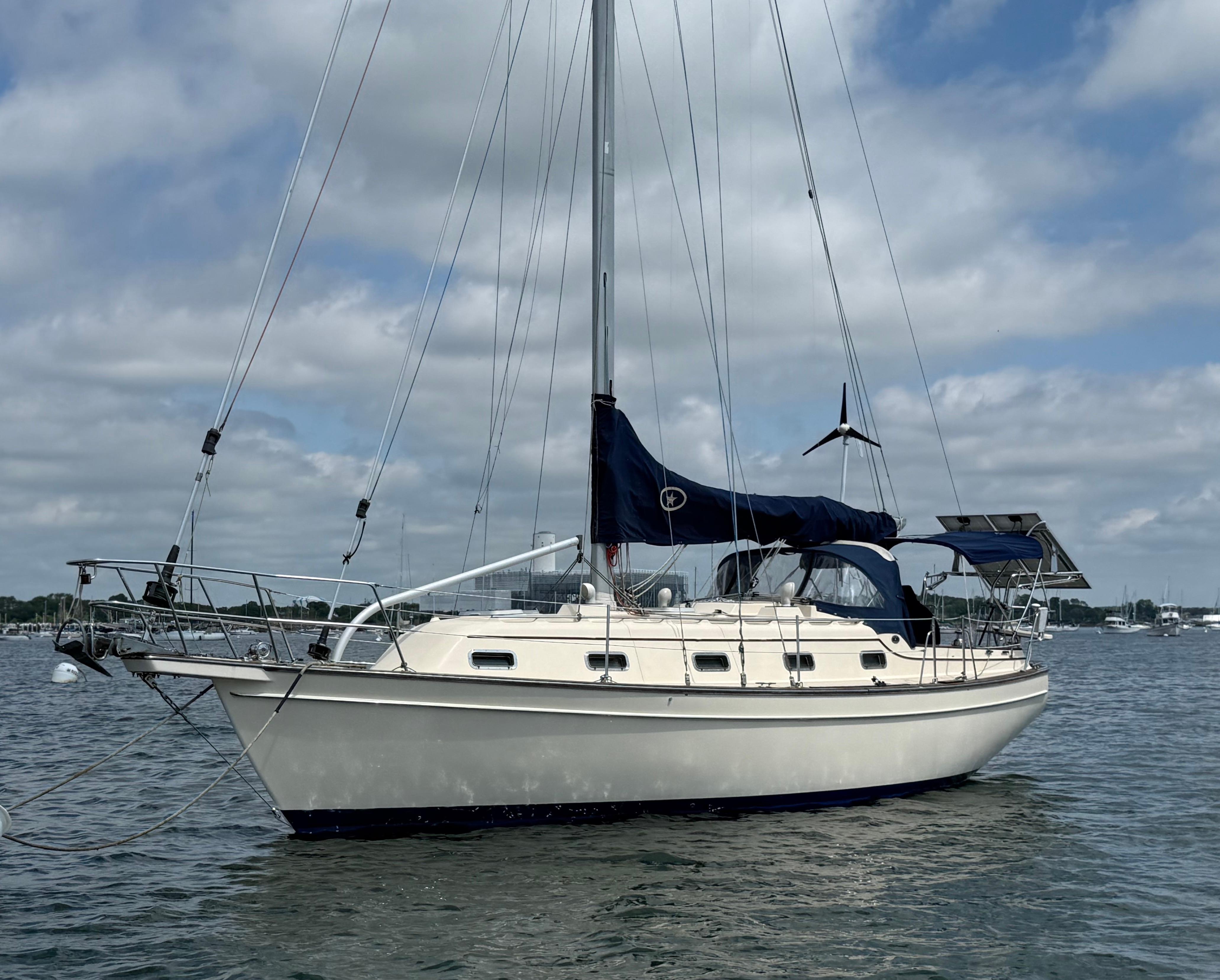Island Packet 350 Sailboat Island Packet 350, 2000 model, anchored on a calm sea under a cloudy sky.