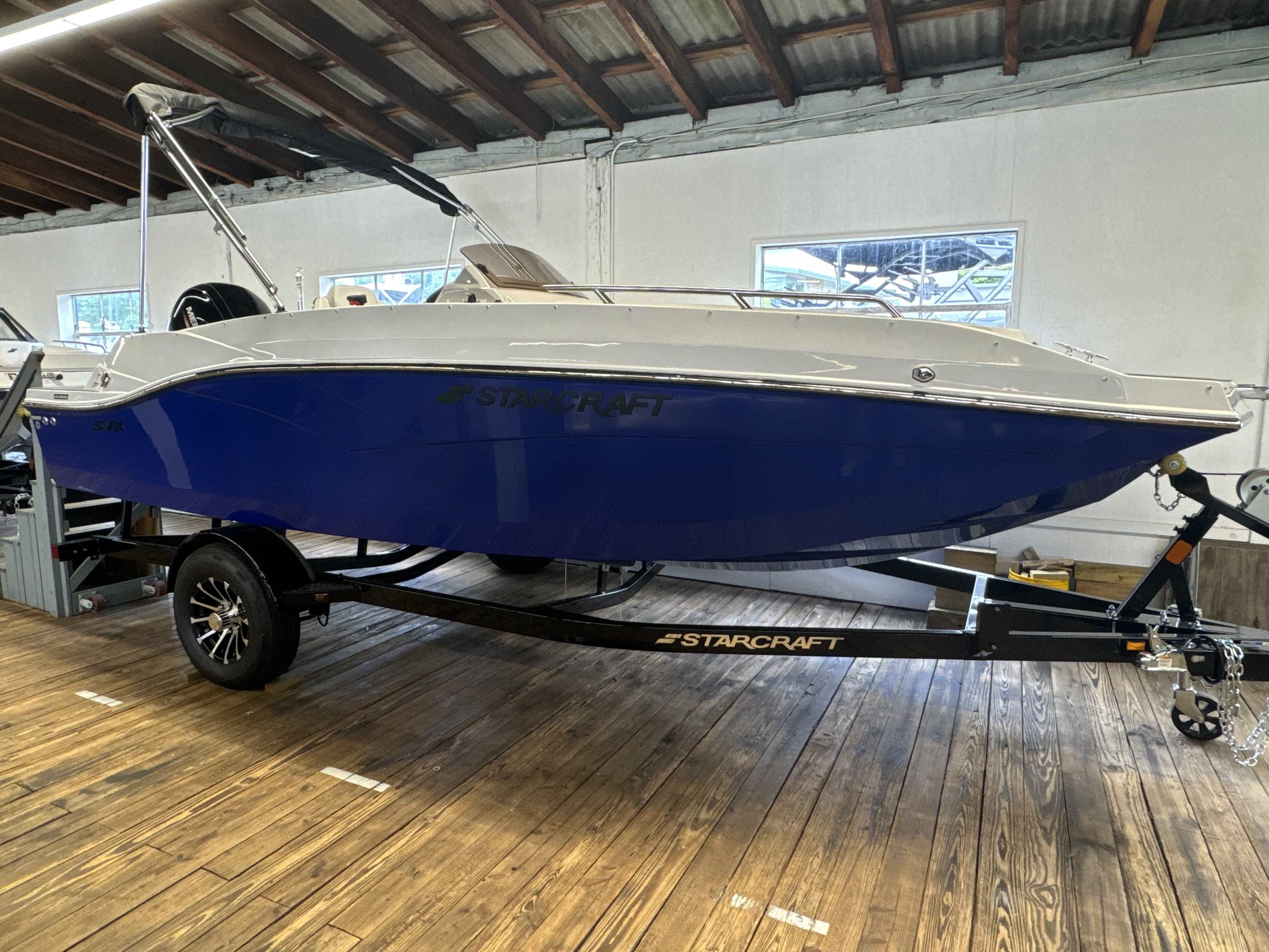 Starcraft SVX 191 OB 2025 Starcraft SVX 191 OB boat on trailer in indoor showroom.