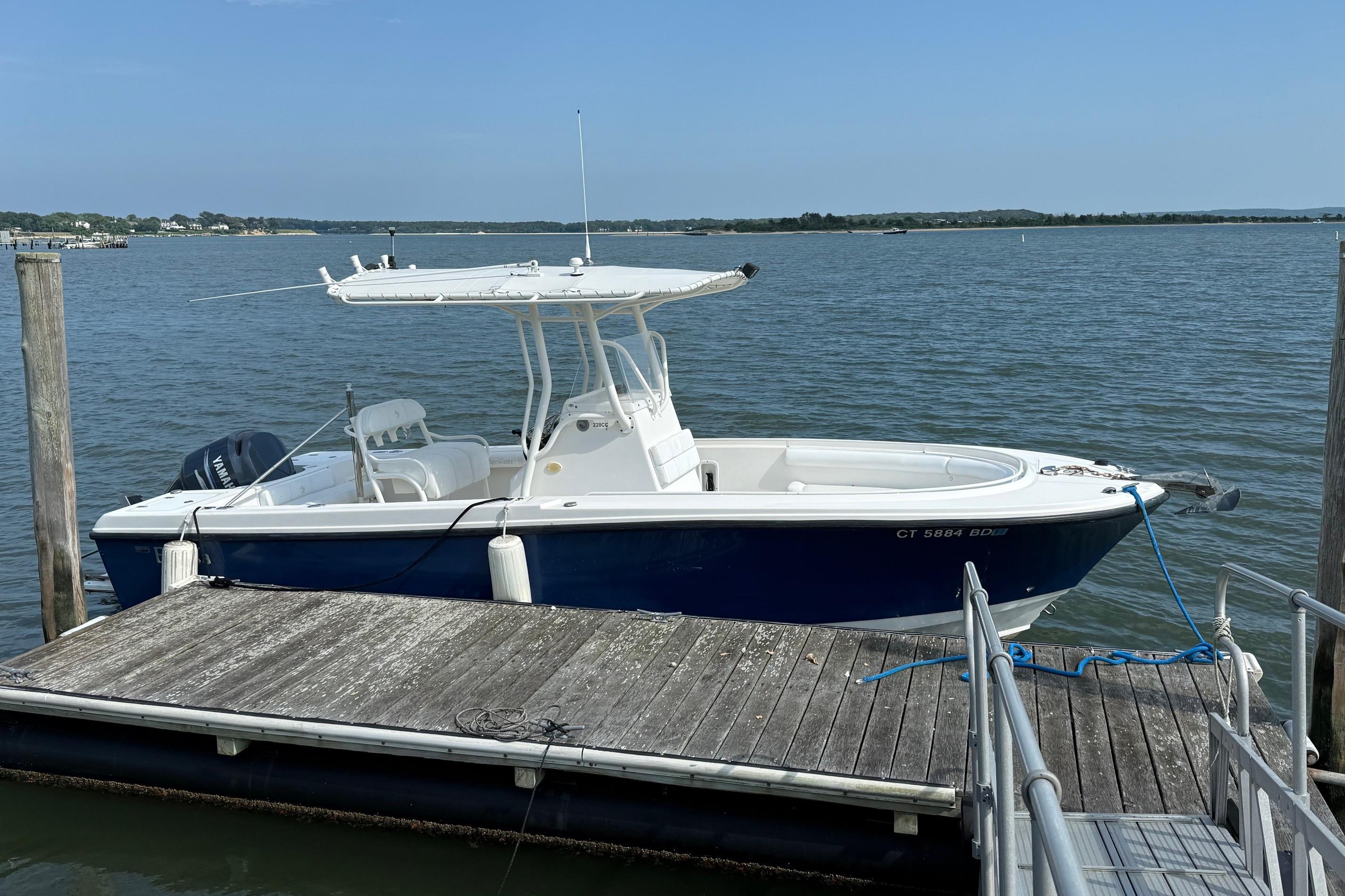 Edgewater 228CC 2008 Edgewater 228CC boat docked on a calm lake under clear skies.