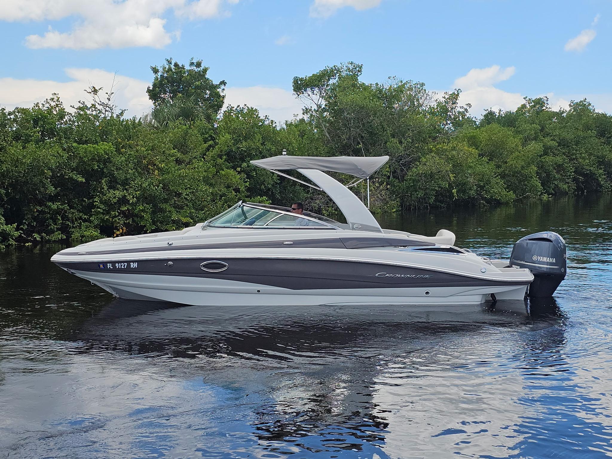 Crownline Eclipse E6 XS 2017 Crownline Eclipse E6 XS boat on calm water, surrounded by lush greenery.