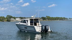 Cutwater C-288 Coupe 2026 Cutwater C-288 Coupe boat on calm water, clear sky background.
