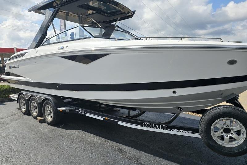 Cobalt A29 2026 Cobalt A29 boat on trailer, sleek design, parked outdoors under cloudy sky.