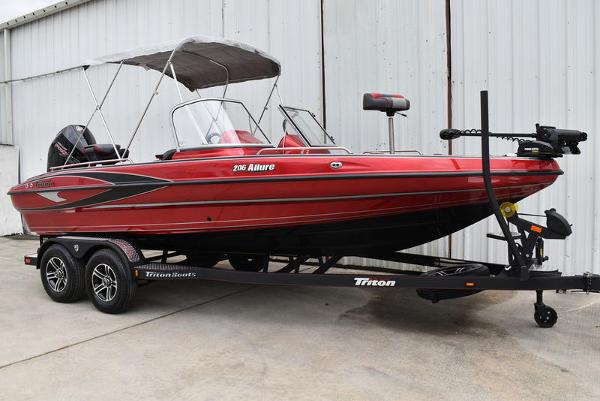 Triton 206 Allure 2024 Triton 206 Allure red fishing boat on trailer with canopy.