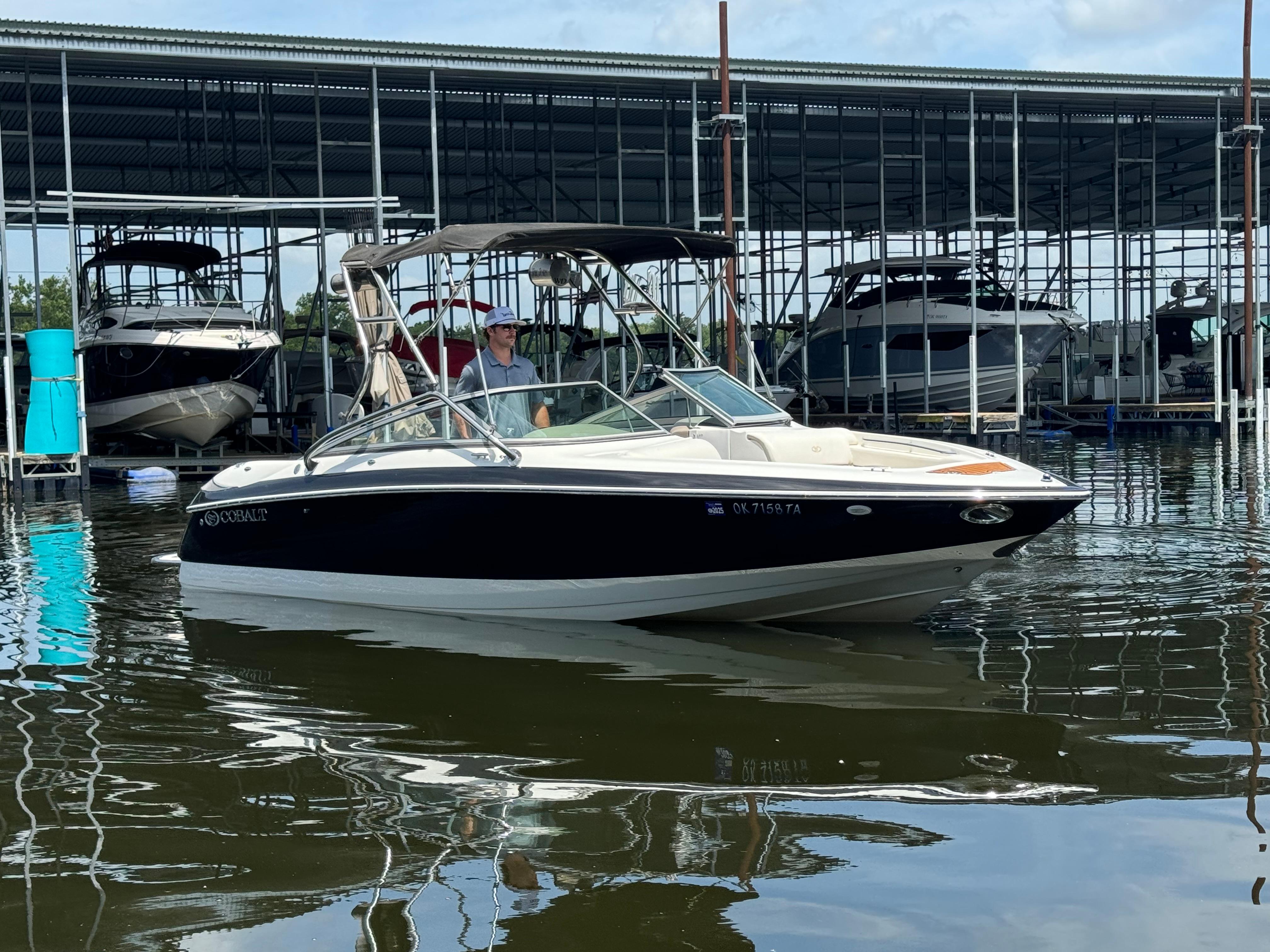 Cobalt 240 2002 Cobalt 240 boat docked in marina, calm water, overcast sky.