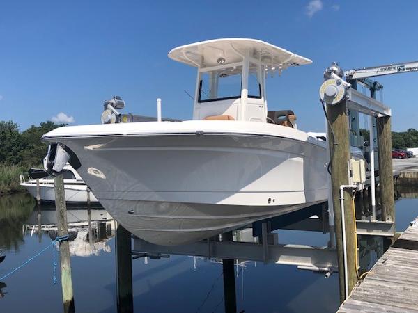 NauticStar 24 XS 2023 NauticStar 24 XS boat docked on a lift under a clear blue sky.