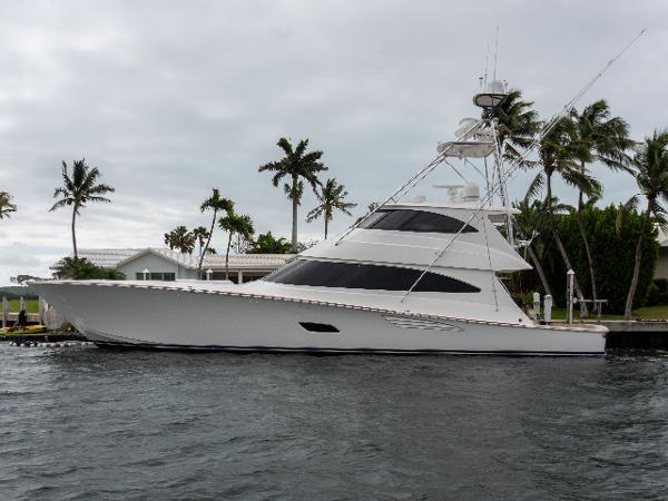 Viking 80 Enclosed Bridge 2019 Viking 80 Enclosed Bridge yacht docked near palm trees, overcast sky.