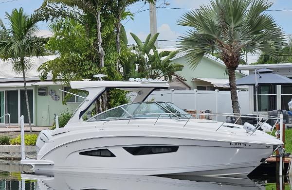 Regal 33 XO 2022 Regal 33 XO boat docked by tropical waterfront home.