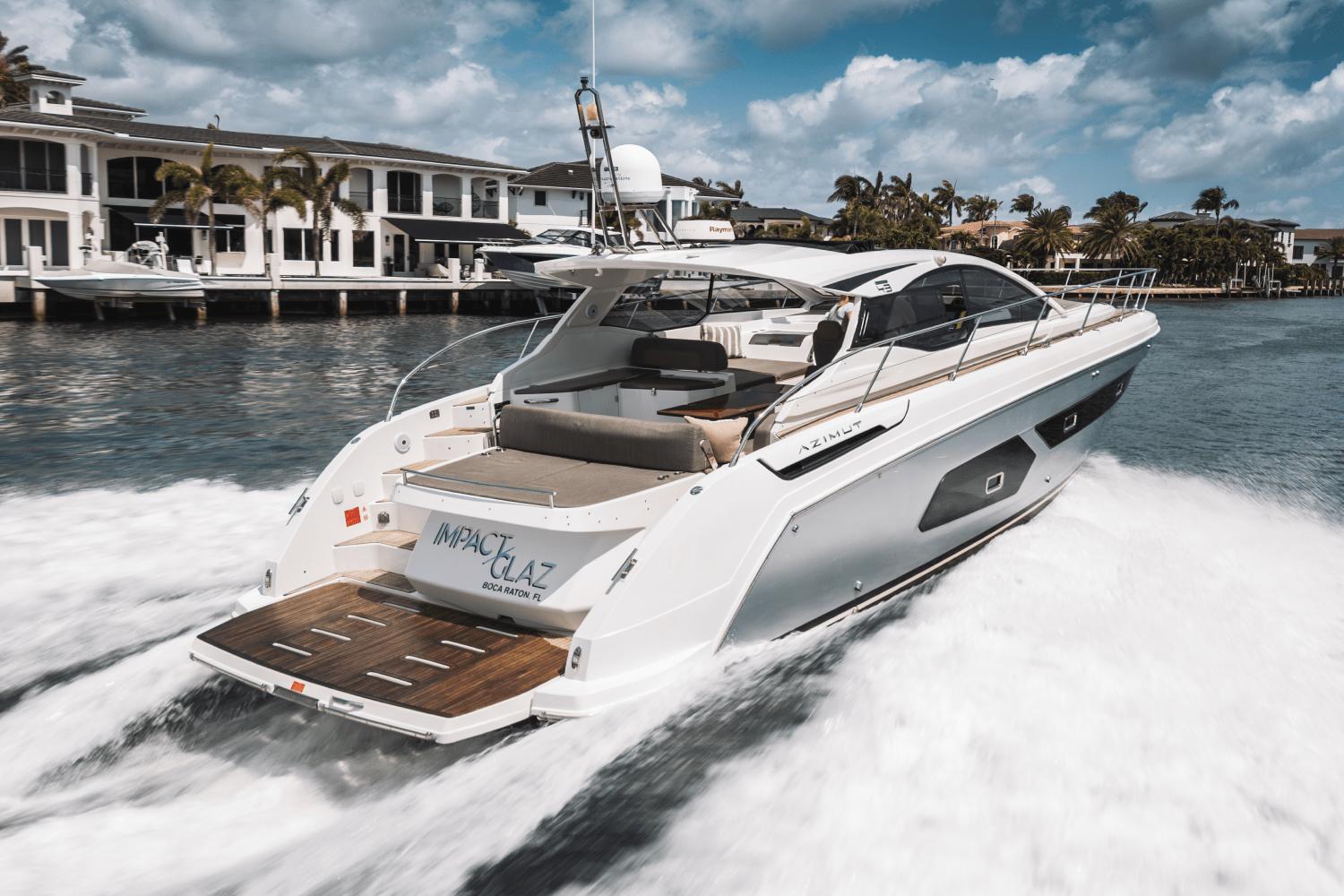Azimut Atlantis 43 2019 Azimut Atlantis 43 yacht cruising near waterfront homes under a cloudy sky.