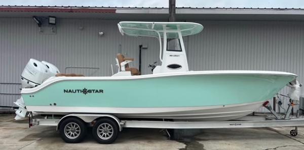NauticStar 252 Legacy 2025 NauticStar 252 Legacy boat on trailer, mint green hull, dual engines, docked outdoors.