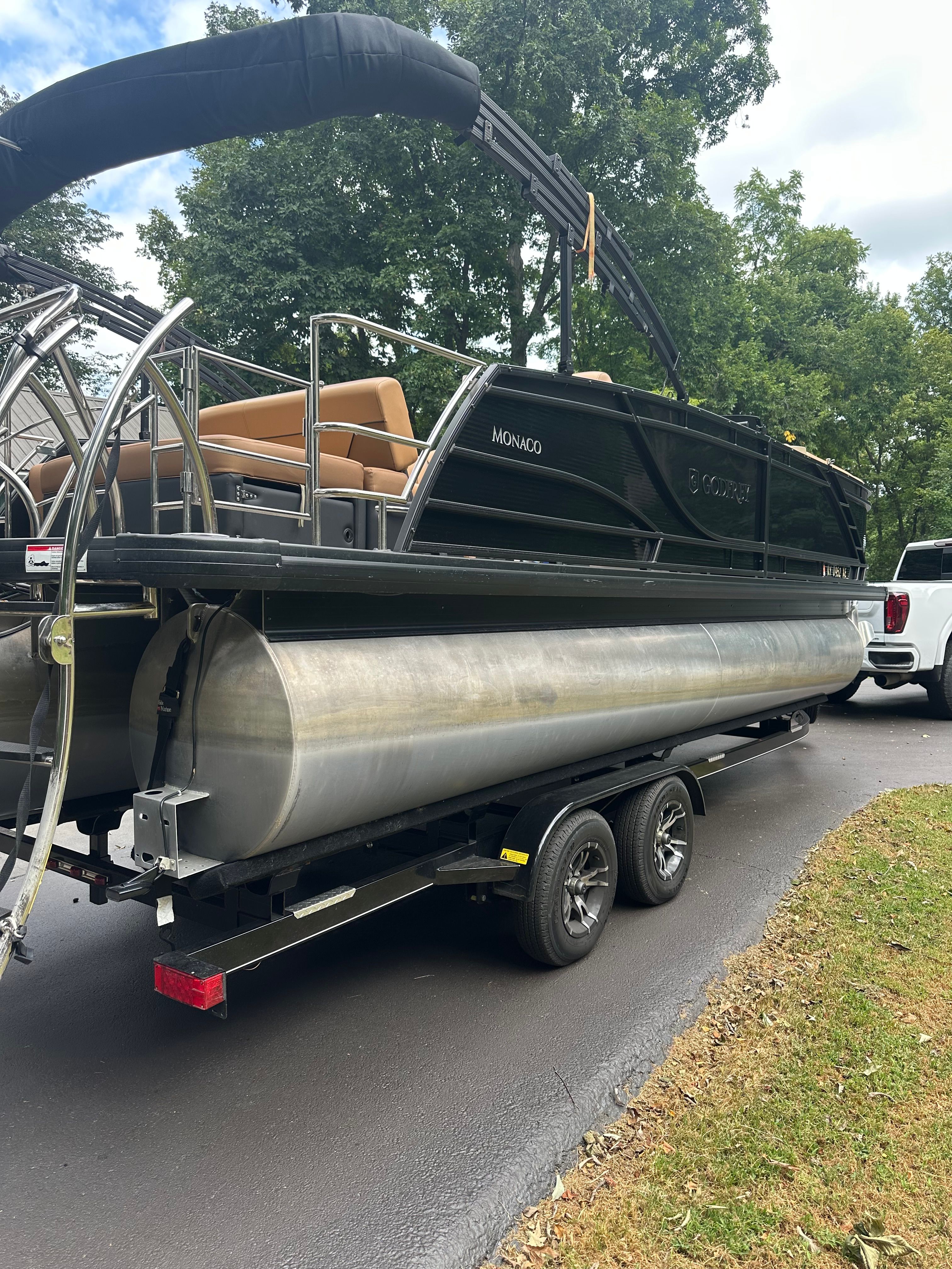 Godfrey Monaco 235 SFL 2021 Godfrey Monaco 235 SFL pontoon boat on trailer, parked on a driveway.