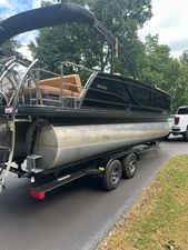 Godfrey Monaco 235 SFL 2021 Godfrey Monaco 235 SFL pontoon boat on trailer, parked on a driveway.