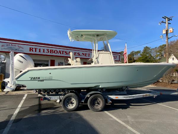 Pathfinder 2400 TRS 2025 Pathfinder 2400 TRS boat on trailer at dealership, sunny day.