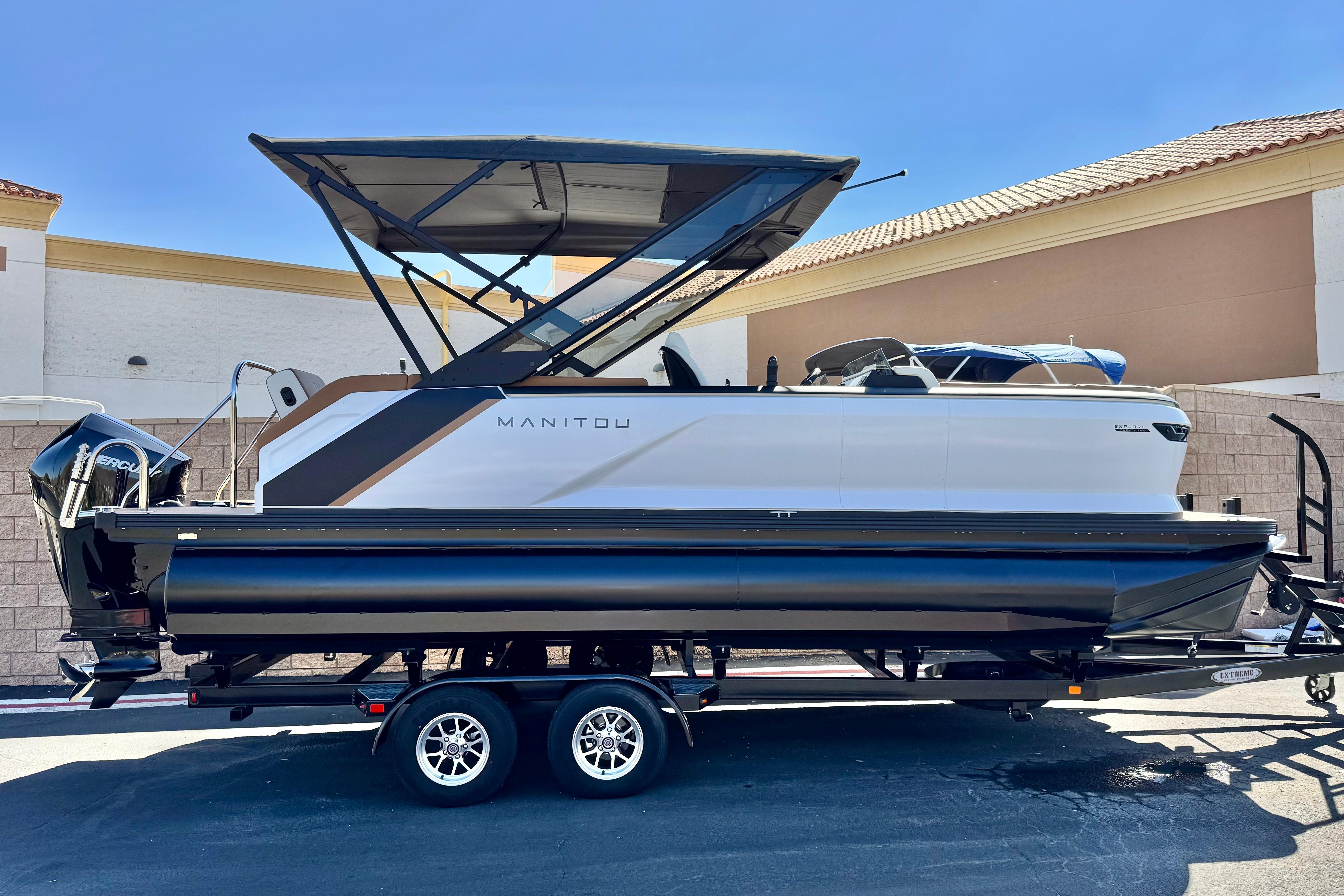 Manitou EXPLORE 22 2026 Manitou EXPLORE 22 pontoon boat on trailer, featuring sleek design and modern canopy.