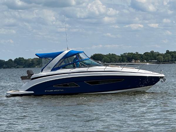 Regal 32 Express 2015 Regal 32 Express boat on a calm lake under a cloudy sky.