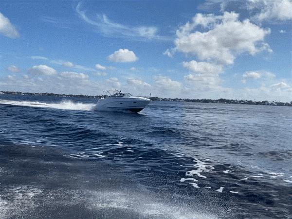 Rinker 280 Rinker 2007 Rinker 280 boat cruising on open water under a partly cloudy sky.
