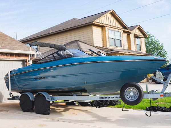Stingray 225SE 2021 Stingray 225SE boat on trailer in suburban driveway.