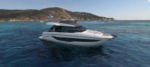 Prestige F4.3 2025 Prestige F4.3 yacht cruising in clear blue waters near a scenic coastline.