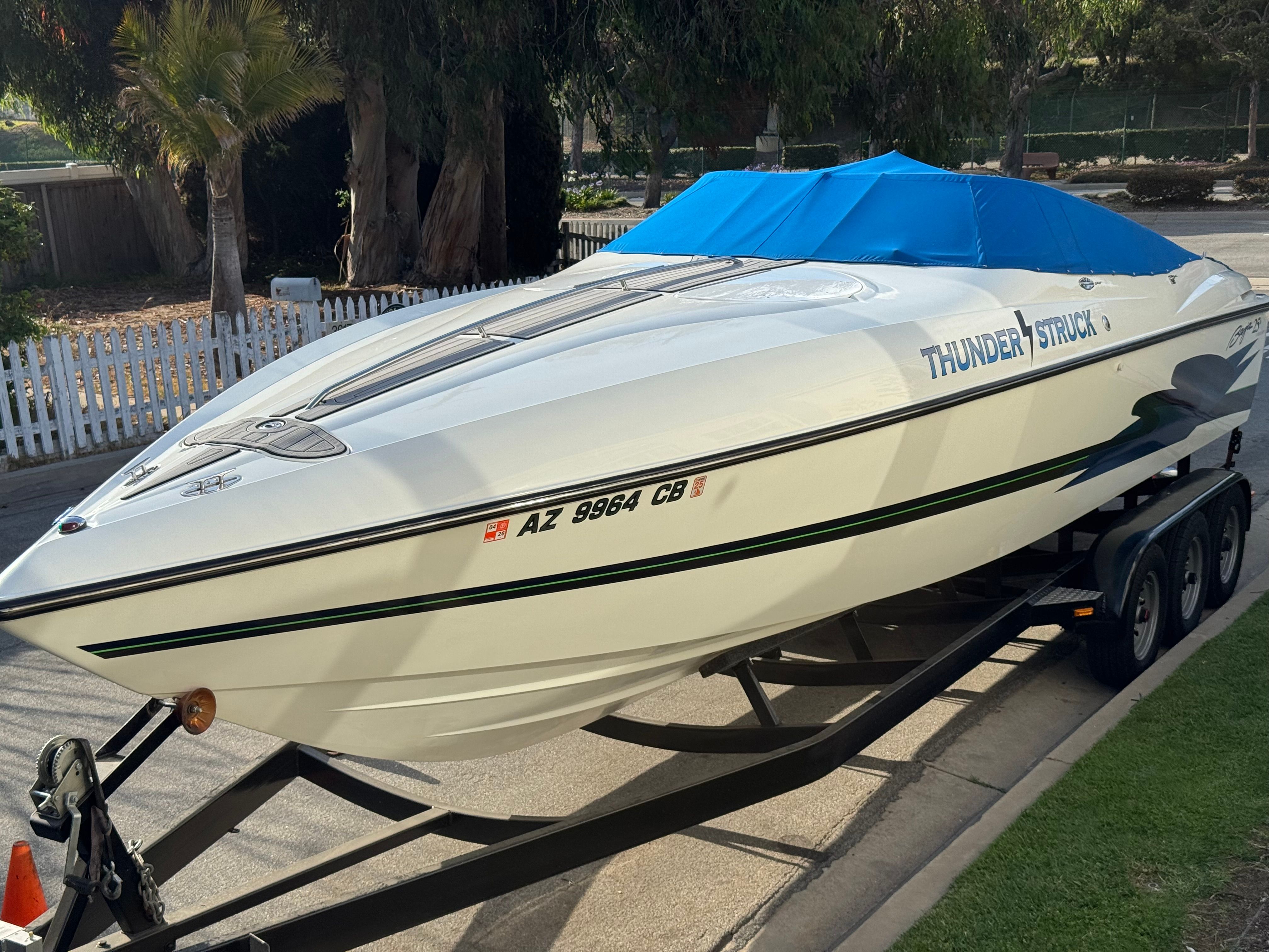 Baja Boss 302 1996 Baja Boss 302 speedboat on trailer, covered with blue tarp, labeled "Thunder Struck."