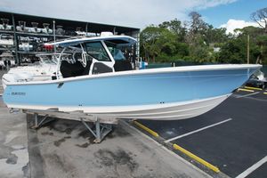 Blackfin 332 CC 2023 Blackfin 332 CC boat in light blue, parked on a stand in a marina.