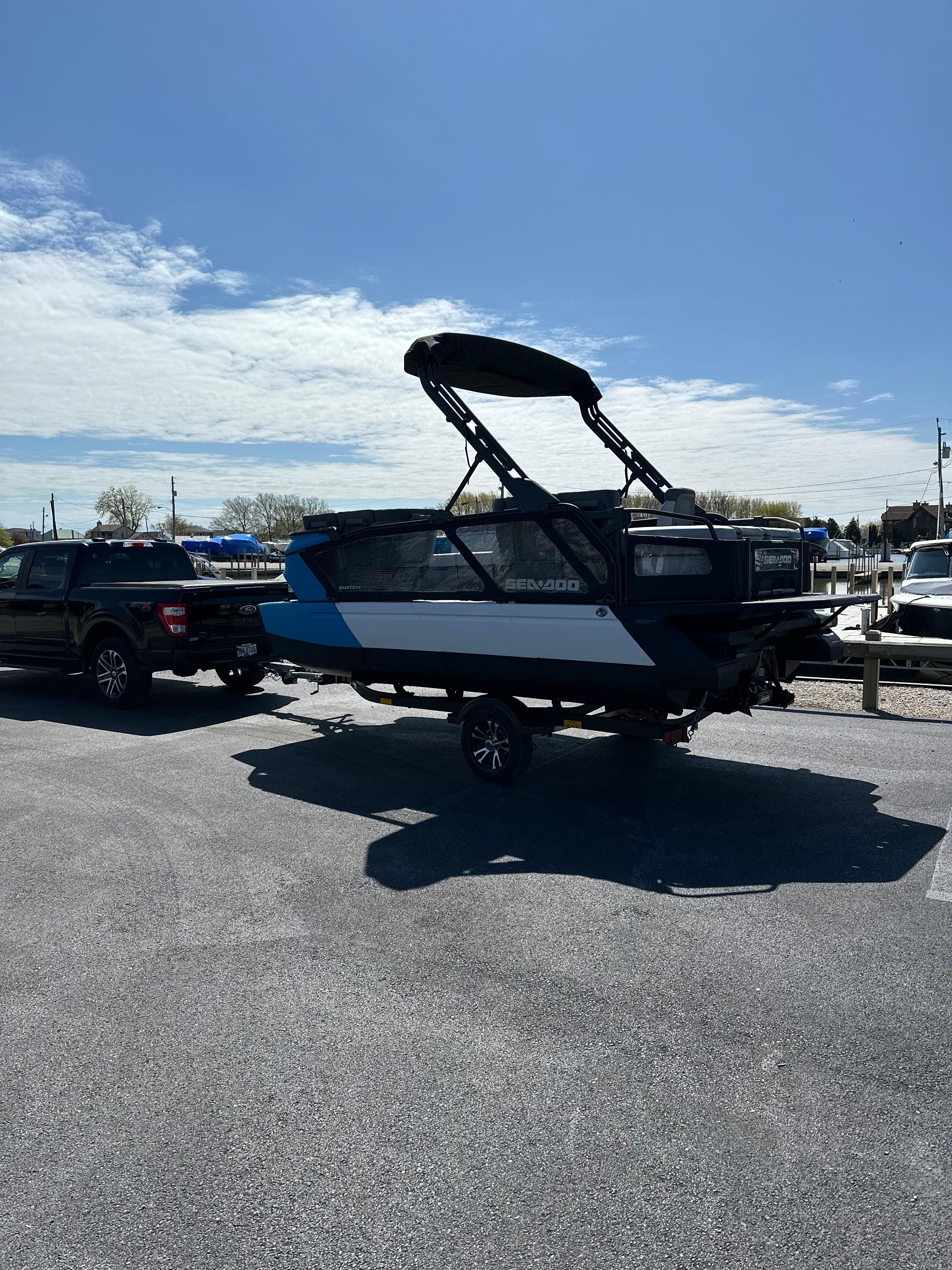 Custom Switch 2023 Custom Switch boat on trailer, parked under clear blue sky.