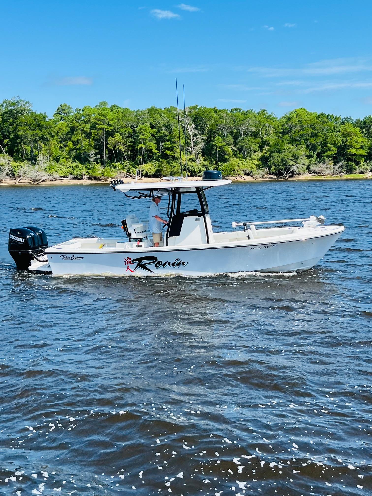 Pair Customs 24 Center Console DV 2023 Pair Customs 24 Center Console DV boat on water, with trees in background.