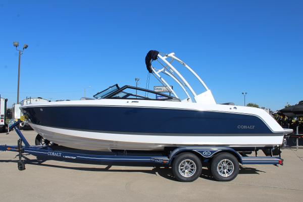 Cobalt Cs23 2025 Cobalt CS23 boat on trailer, blue and white design, parked outdoors.