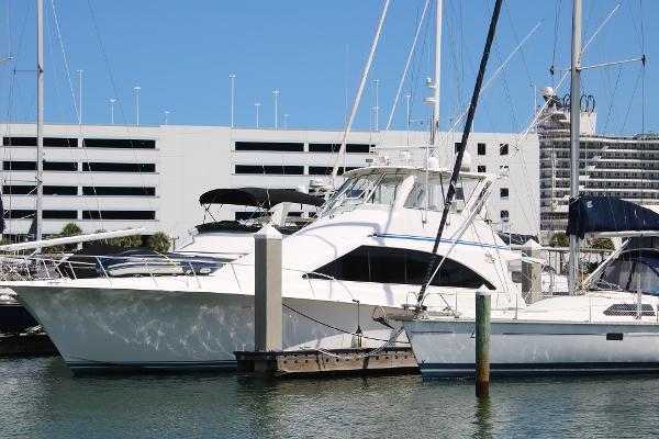 Ocean Yachts Yacht 1999 Ocean Yachts model docked at marina, surrounded by other boats and modern buildings.