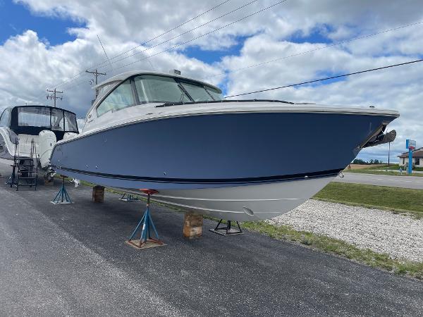 Pursuit DC 326 Dual Console 2024 Pursuit DC 326 Dual Console boat on display under cloudy sky.