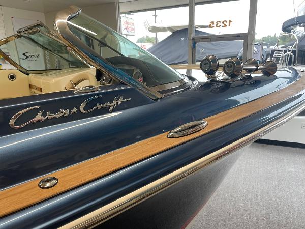 Chris-Craft Launch 27 2025 Chris-Craft Launch 27 boat with sleek design and wood accents in showroom.