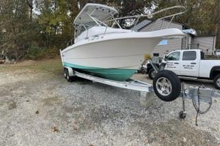 Pro-Line 251 Pro-line 1995 Pro-Line 251 boat on trailer, parked outdoors near trees and a truck.