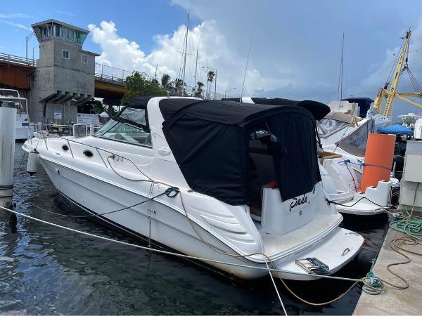 Sea Ray Sundancer 350 1996 Sea Ray Sundancer 350 docked at marina, featuring black canopy and sleek white hull.
