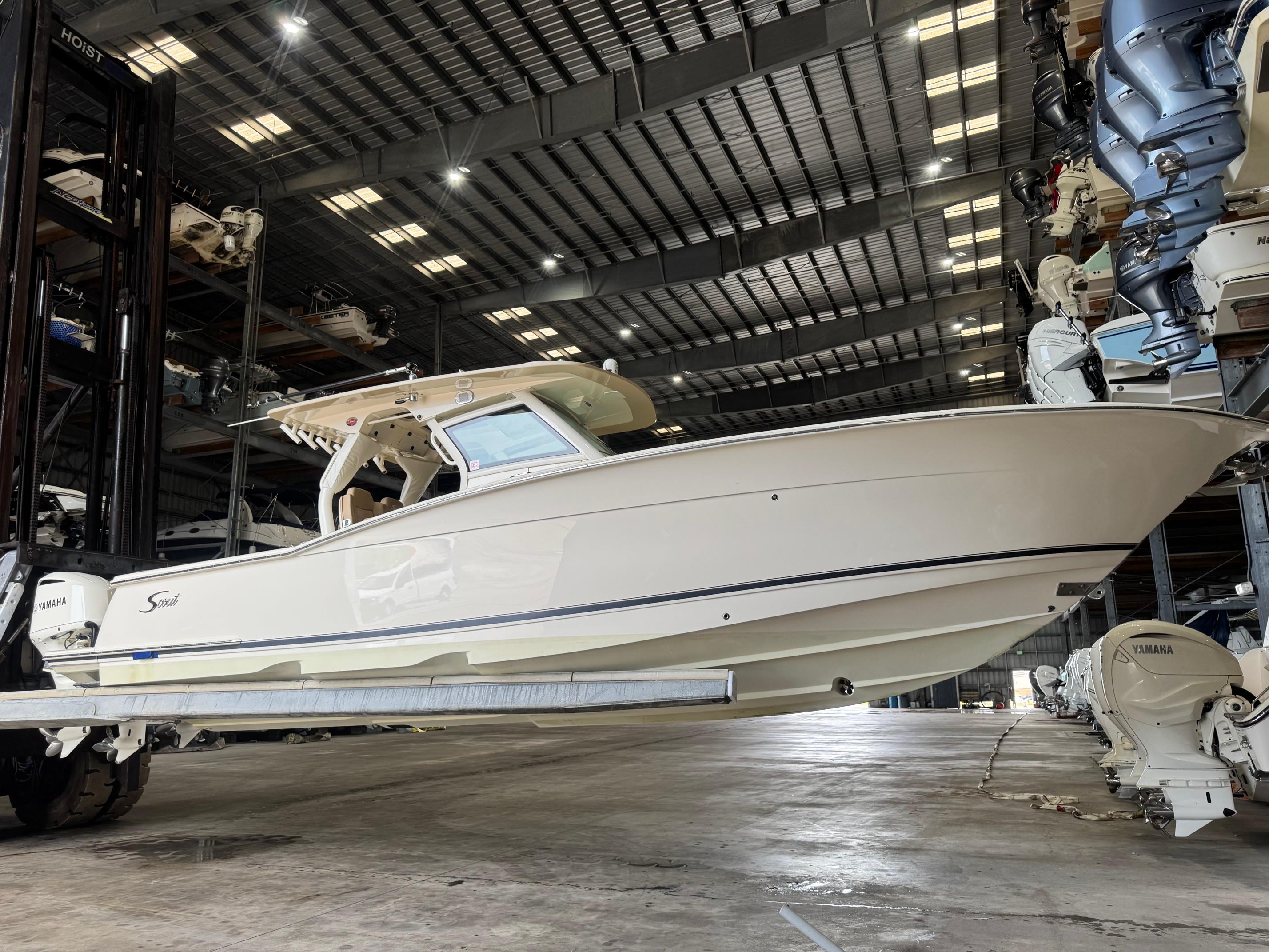 Scout 350 LXF 2019 Scout 350 LXF boat in storage facility, side view with Yamaha engines.
