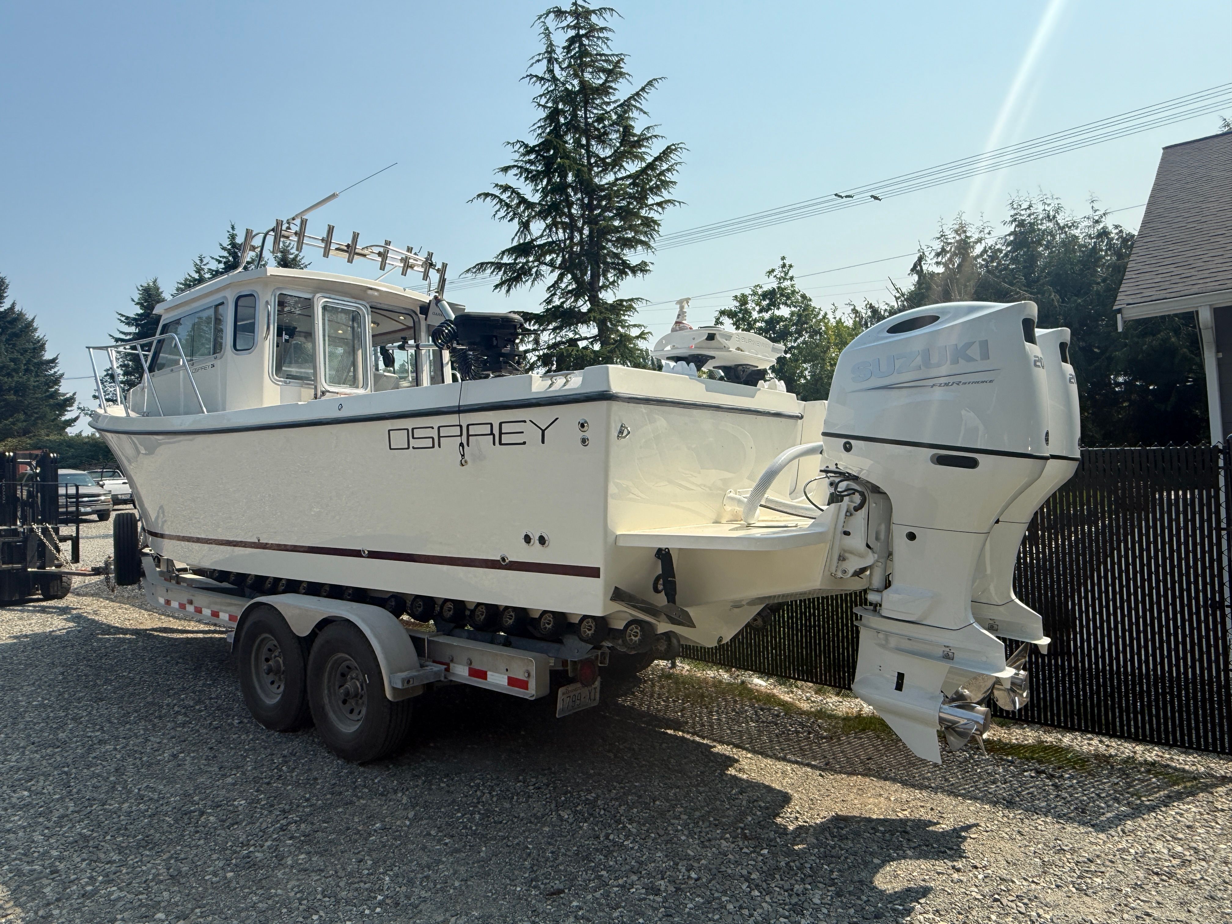 Osprey 26 Fisherman 2007 Osprey 26 Fisherman boat with Suzuki outboard motor on a trailer.