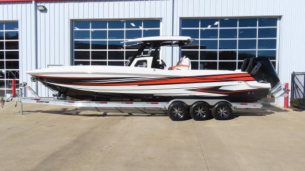 Sunsation 32 CCX 2025 Sunsation 32 CCX boat with vibrant orange and black accents on a trailer.