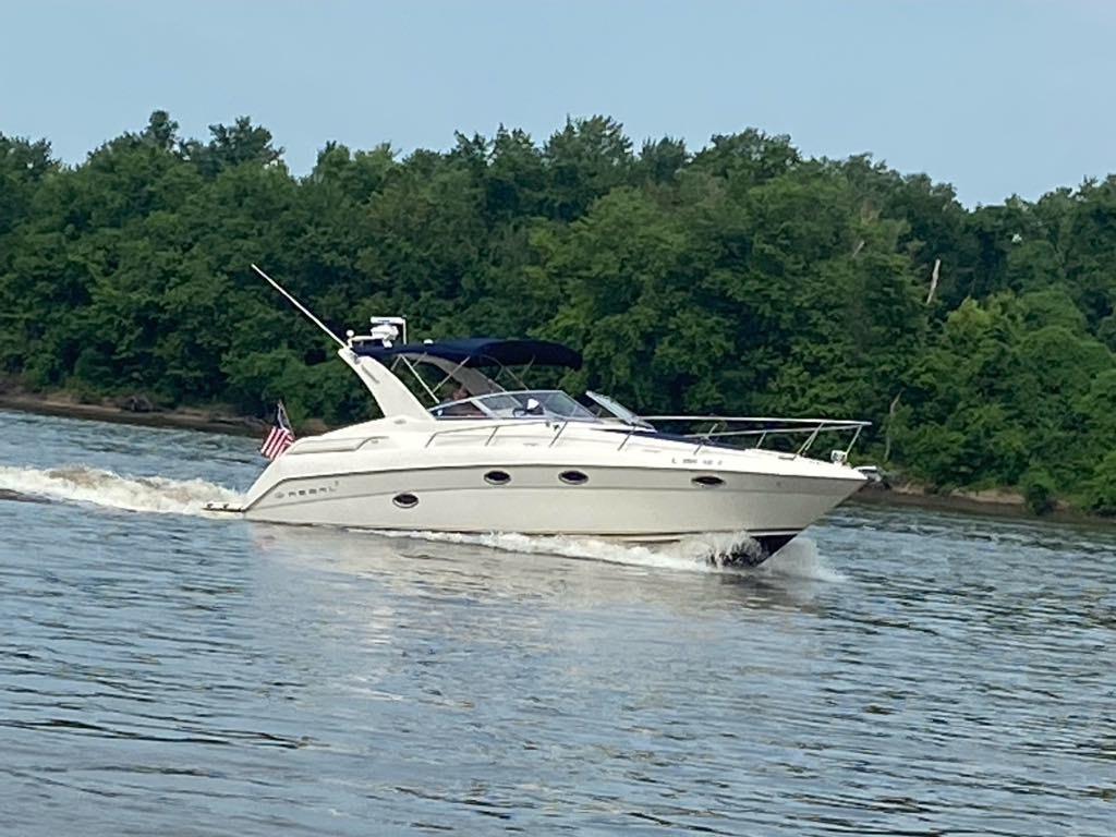Regal Commodore 3260 Regal Commodore 3260 boat cruising on a river, 2000 model, with lush green trees in background.