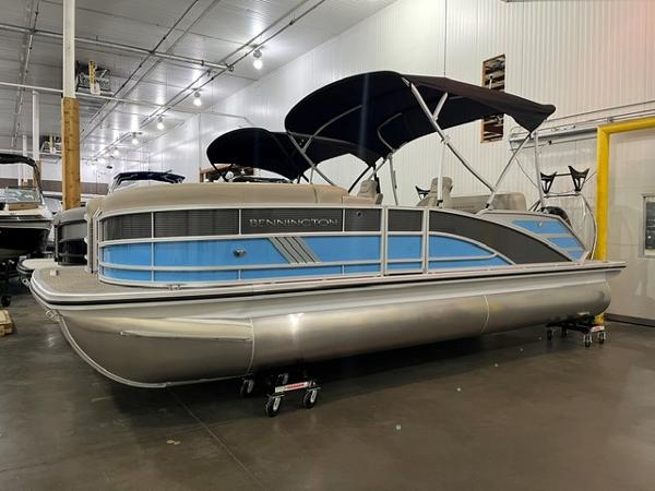 Bennington M22 Swingback 2025 Bennington M22 Swingback pontoon boat in showroom, featuring blue accents and black canopy.