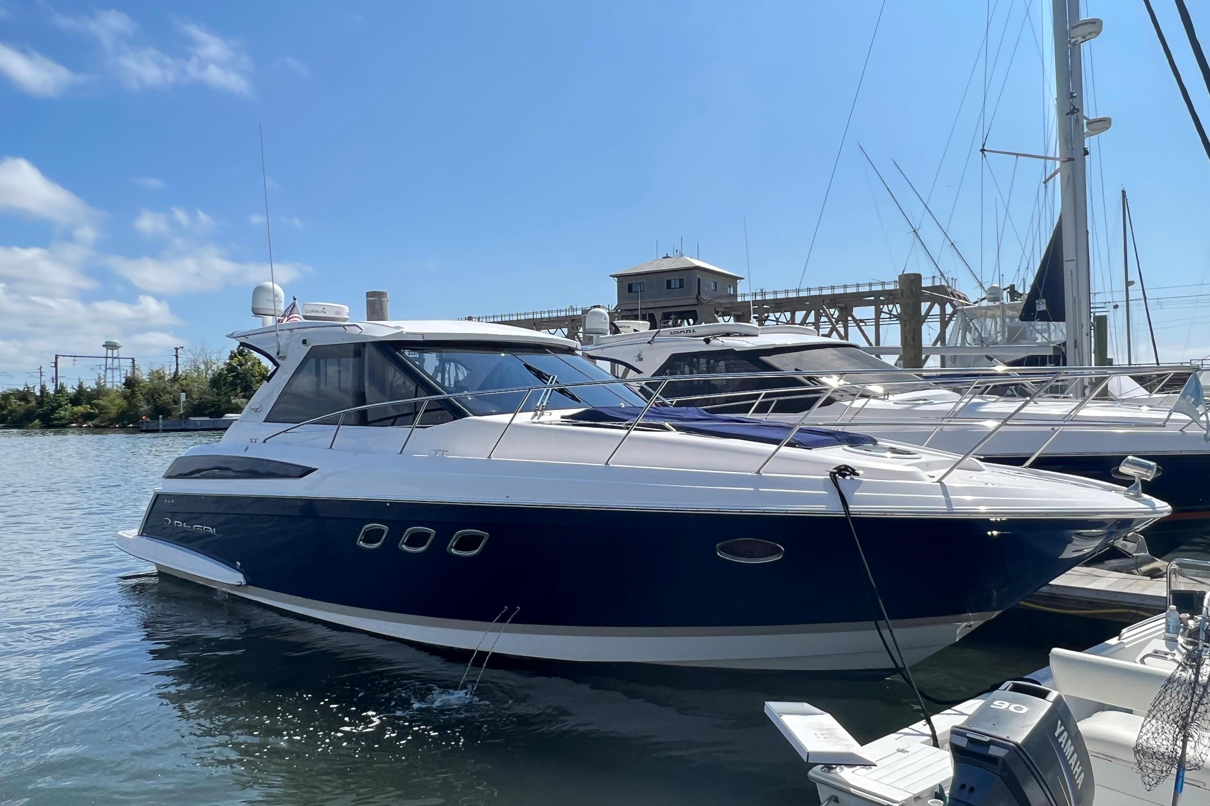 Regal 42 Sport Coupe 2011 Regal 42 Sport Coupe yacht docked in a marina under clear blue skies.