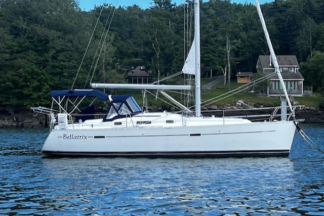 Beneteau 343 Sloop 2006 Beneteau 343 Sloop sailboat named Bellatrix on calm water near wooded shoreline.