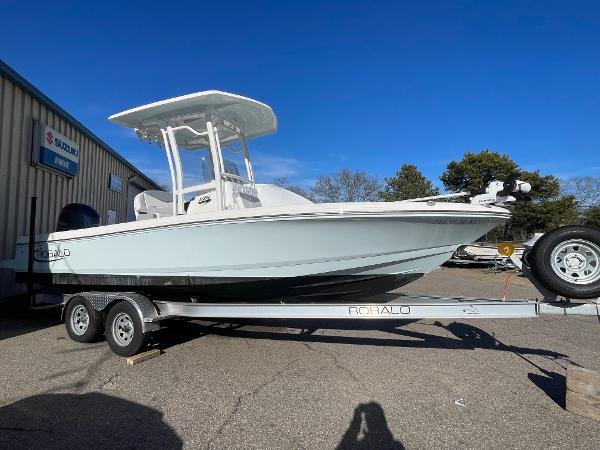 Robalo 226 Cayman 2022 Robalo 226 Cayman boat on trailer, parked outdoors under clear blue sky.