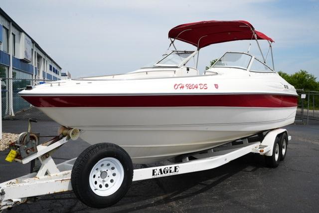 Wellcraft 260SE 1995 Wellcraft 260SE boat on trailer with red canopy, parked outdoors.