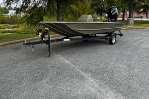 Tracker Grizzly 1648 SC 2025 Tracker Grizzly 1648 SC boat on trailer in parking lot.