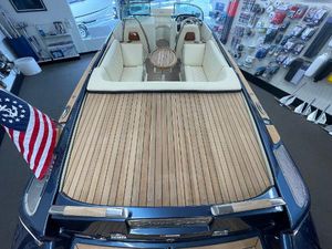 Chris-Craft Launch 27 2025 Chris-Craft Launch 27 boat with teak deck and American flag in showroom.