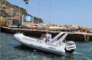 SACS 680 2006 SACS 680 boat with 200cv engine near a rocky shoreline and dock.
