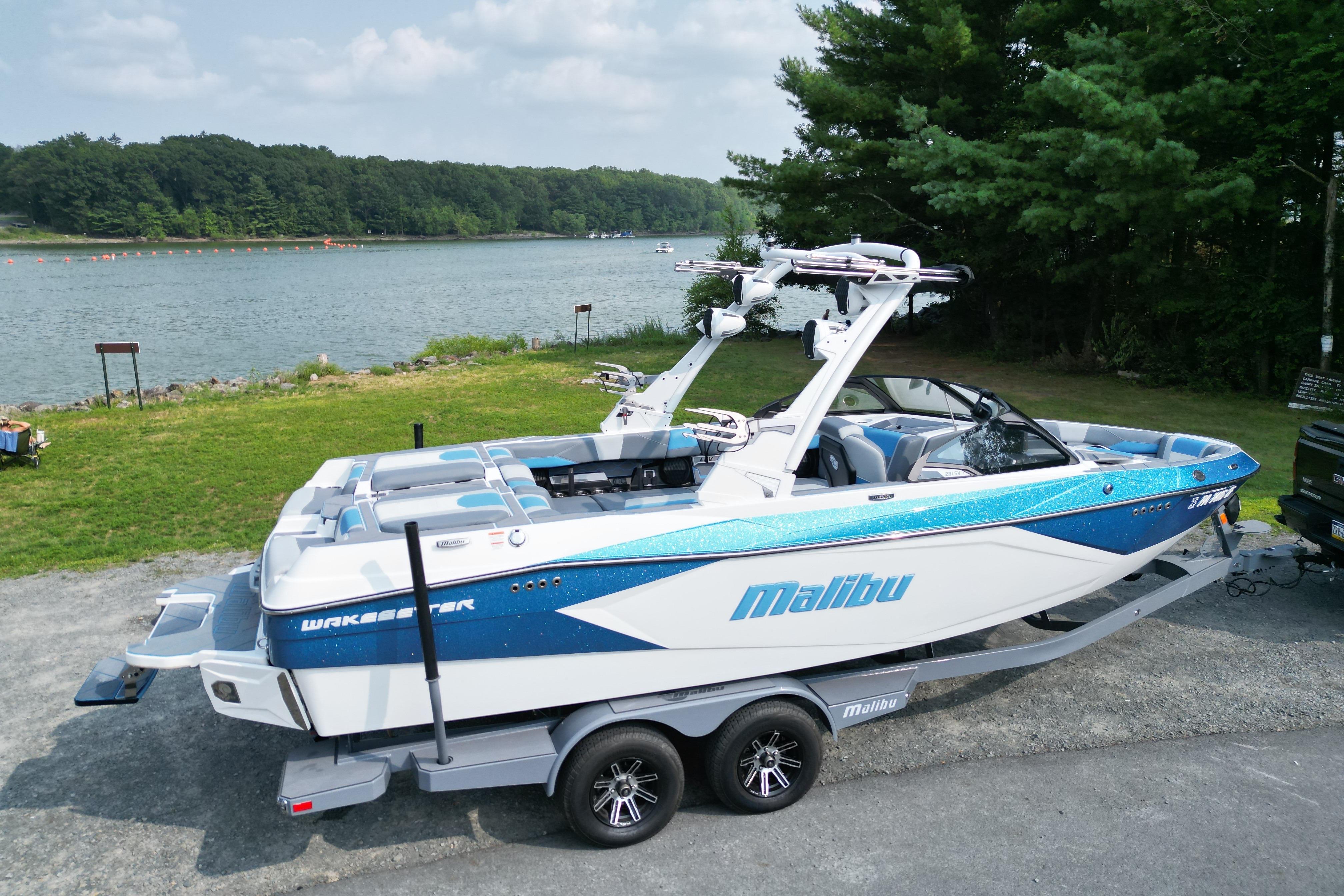 Malibu Wakesetter 23 LSV 2024 Malibu Wakesetter 23 LSV boat on trailer by a scenic lake.