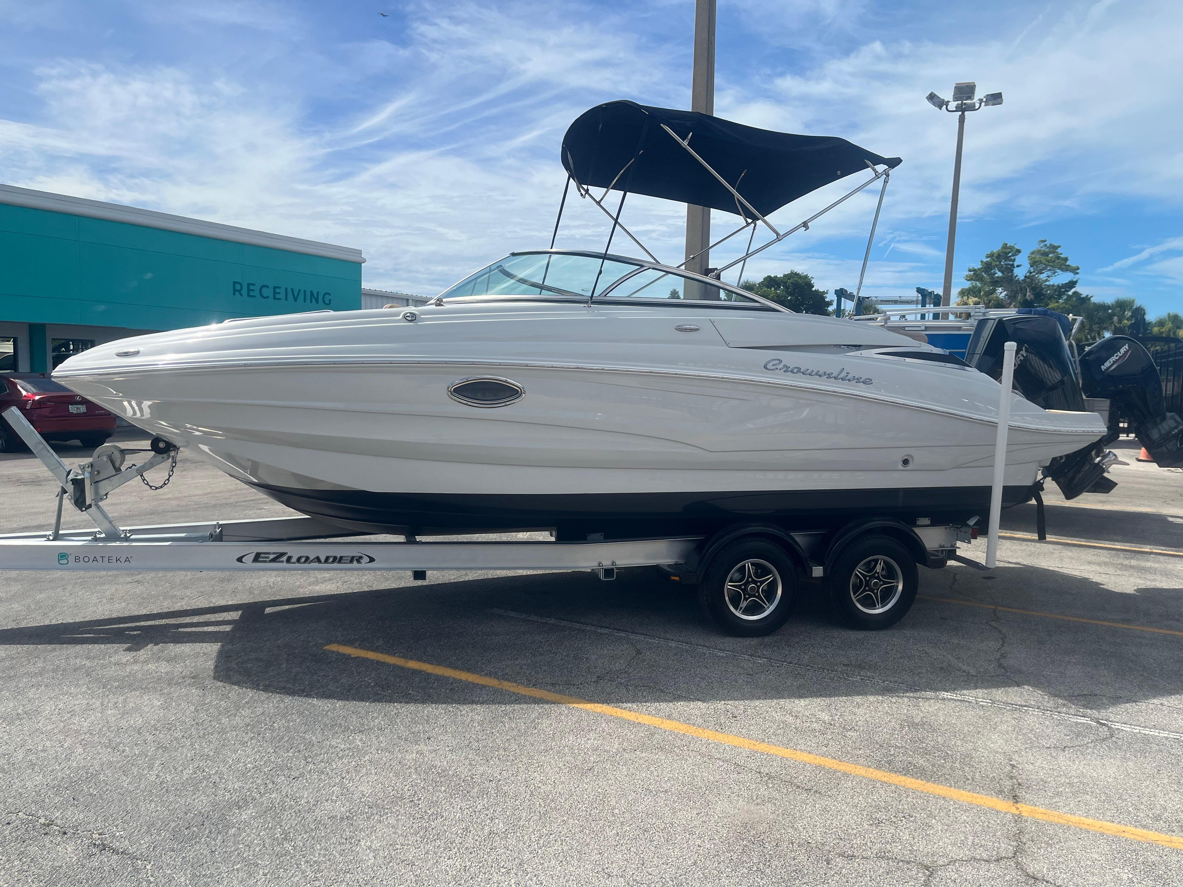 Crownline Eclipse E235 XS 2022 Crownline Eclipse E235 XS boat on trailer, parked outdoors under blue sky.