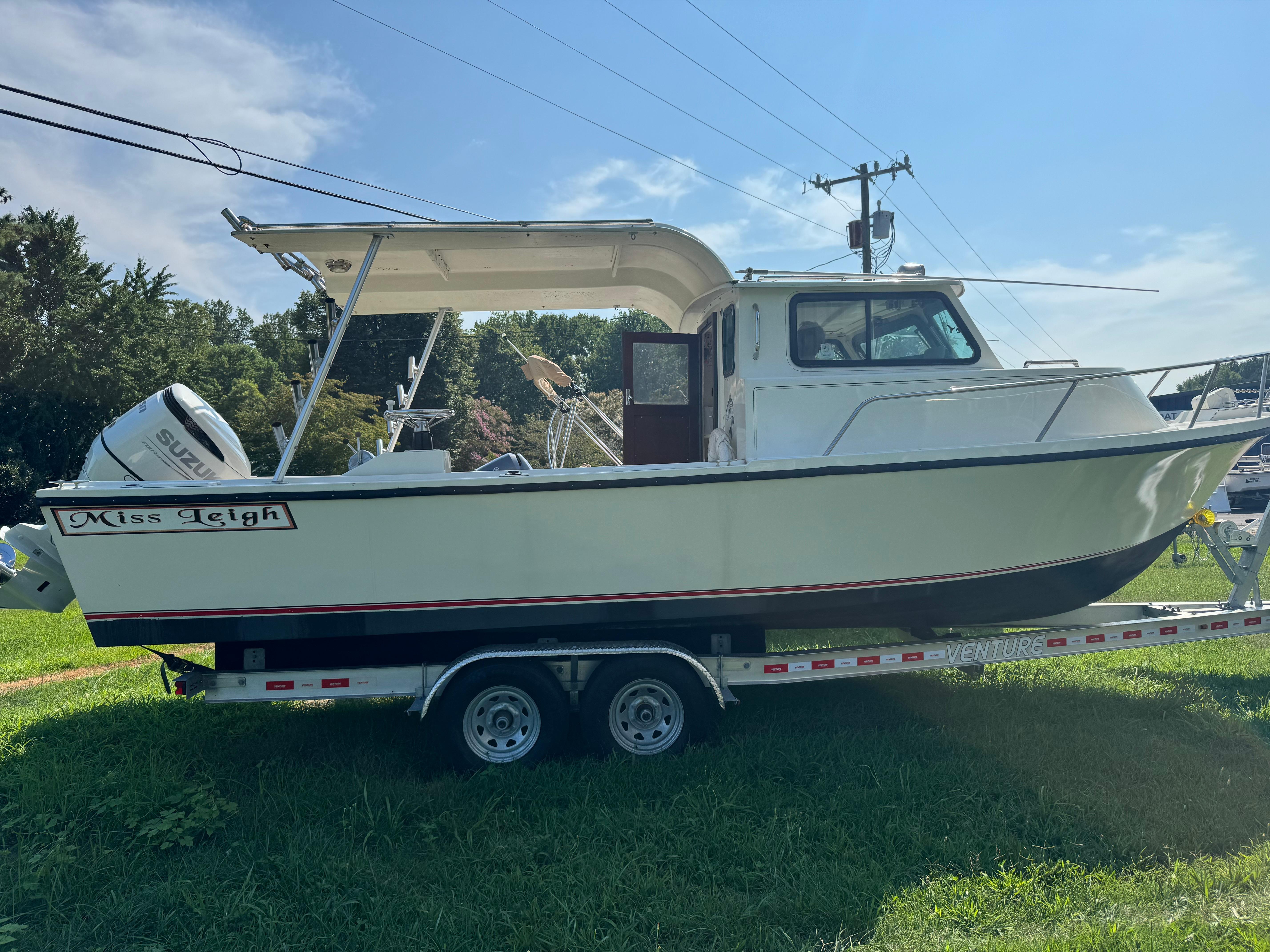 Parker 2510 1987 Parker 2510 boat on trailer, side view, with Suzuki outboard motor.
