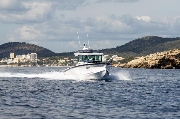 Axopar 29 XC Cross Cabin 2025 Axopar 29 XC Cross Cabin cruising on open water, scenic coastal backdrop.