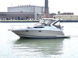 Regal 30 Express 2013 Regal 30 Express boat on water near industrial buildings.